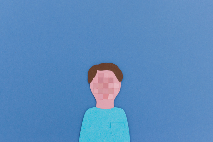 Paper cutout of human portrait with pixeled face instead of face for concept of anonymity