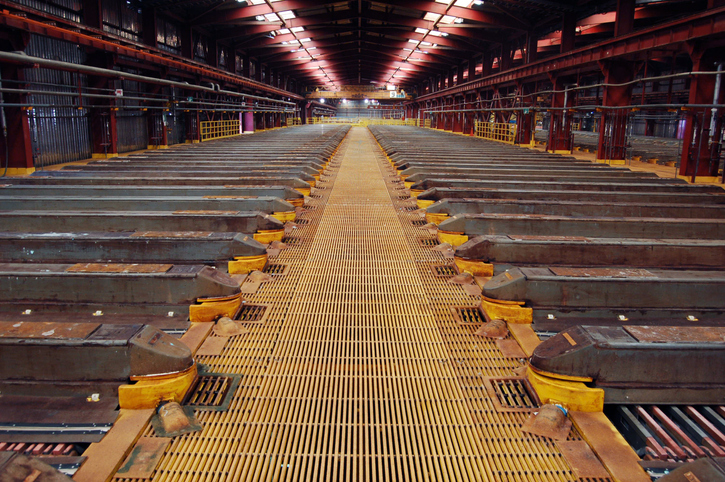 Thousands of sheets of copper are grown in an enormous acid bath at a mining processing facility in Chile. The symmetry of the sky lights and yellow grated floor stretches to a convergence point after dozens of baths.