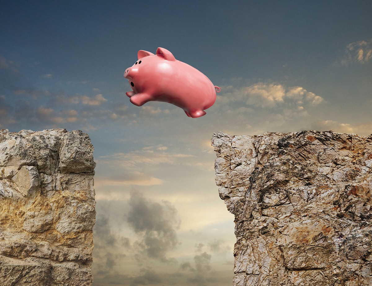 A piggy bank leaps across a chasm in an image about investment and savings opportunities.