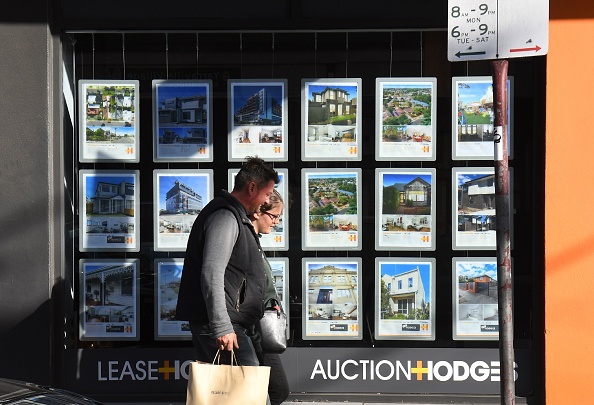 A couple walks past a real estate agent's window advertising houses for sale and auction in Melbourne on May 1, 2019. - Australian property prices fell faster in the past year than at any time since the global financial crisis, a closely watched report said May 1, fuelling speculation of a pre-election interest rate cut. (Photo by William WEST / AFP)        (Photo credit should read WILLIAM WEST/AFP via Getty Images)