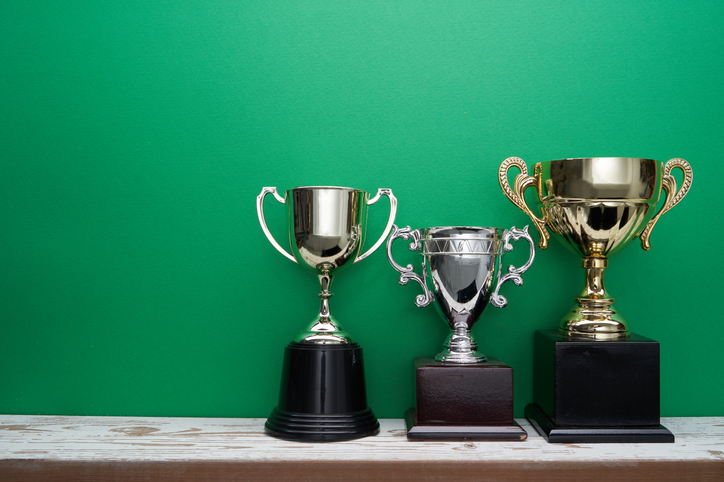 group of trophy on shelf against green background