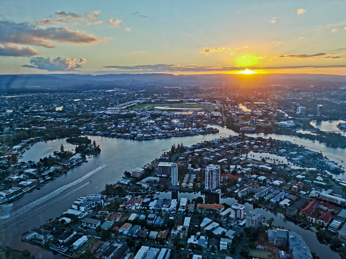 Gold Coast, Australia - April 25, 2021: Aerial panorama view of High-rise building sky scrapers with inland canal and Surfer Paradise city skyline landscape with Sunset light in the evening.