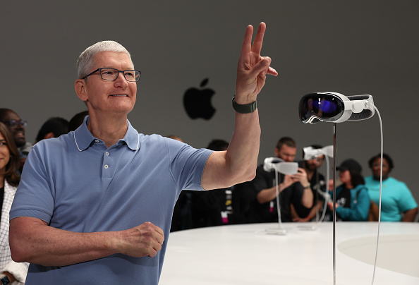 CUPERTINO, CALIFORNIA - JUNE 05: Apple CEO Tim Cook stands next to the new Apple Vision Pro headset displayed during the Apple Worldwide Developers Conference on June 05, 2023 in Cupertino, California. Apple CEO Tim Cook kicked off the annual  conference with the announcement of the new Apple Vision Pro mixed reality headset. (Photo by Justin Sullivan/Getty Images)