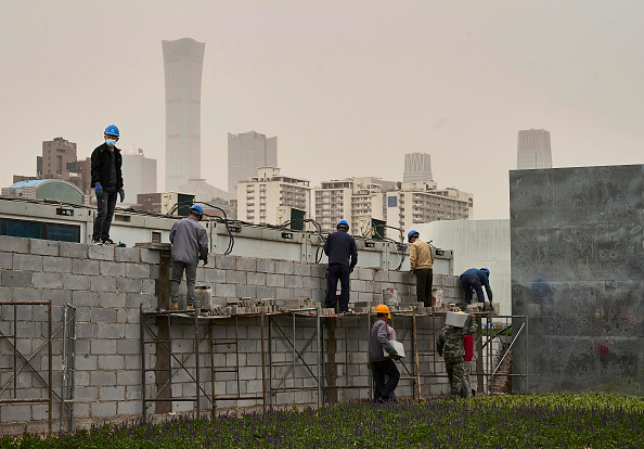 BEIJING, CHINA - APRIL 14: Construction workers work at a construction site at at a construction site at the new Workers Stadium  (Photo by Kevin Frayer/Getty Images)