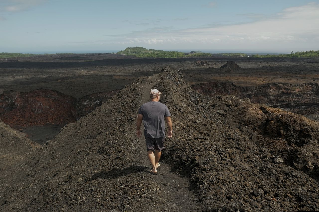 Kris Burmeister, whose home was destroyed by lava in 2018, has bought lots inundated by the flow and gives private tours of the rift zone.